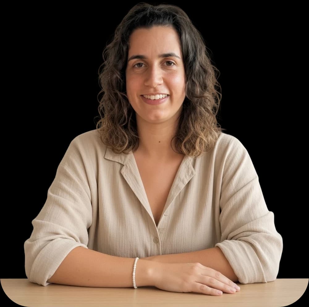 Alba Valero, sentada a una mesa, sonriendo
